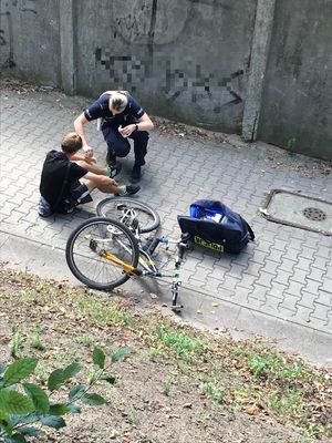 policjantka udziela pomocy poszkodowanemu mężczyźnie